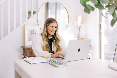 a happy woman working on a computer