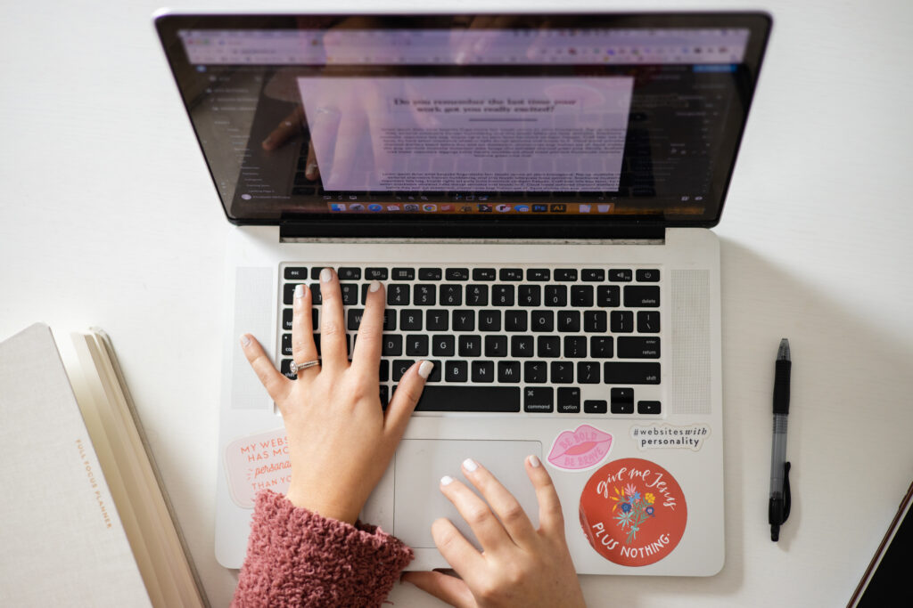 Website Refresh: Hands typing on a laptop computer.